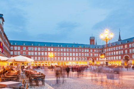 Plaza Mayor, a large historic- square in central Madrid, Spain illuminated at twilight blue hour.